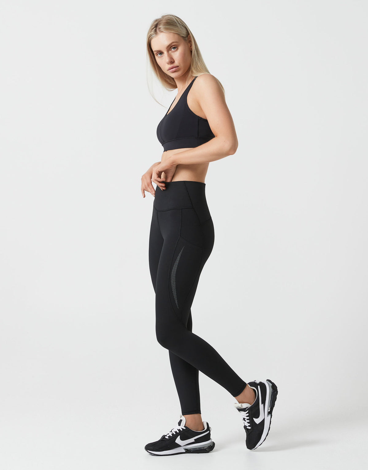 Woman wearing a black athletic outfit on a white background