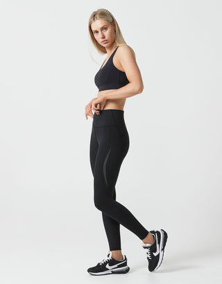Woman wearing a black athletic outfit on a white background