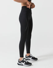 Person wearing black leggings and Nike shoes on a white background