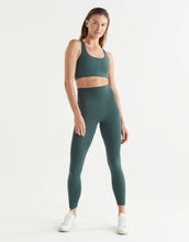 Woman wearing a green athletic outfit on a white background