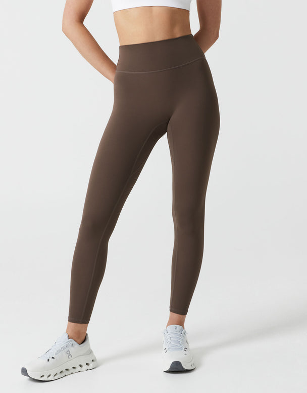 Brown leggings worn by a person on a white background