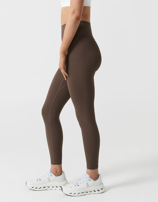Brown leggings worn by a person on a white background