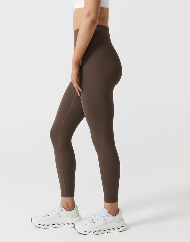Brown leggings worn by a person on a white background