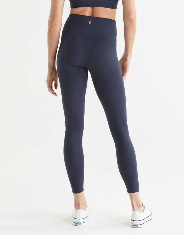 Woman wearing navy blue leggings on a white background