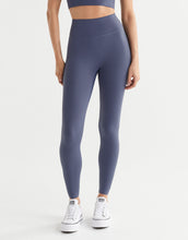 Person wearing purple leggings and white sneakers on a white background