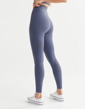 Person wearing high-waisted blue leggings on a white background