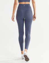 Person wearing high-waisted blue leggings on a white background