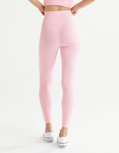 A woman wearing pink leggings on a white background.