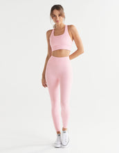 Woman wearing a pink athletic outfit on a white background