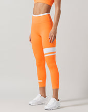 Orange leggings with white stripes worn by a person on a light gray background
