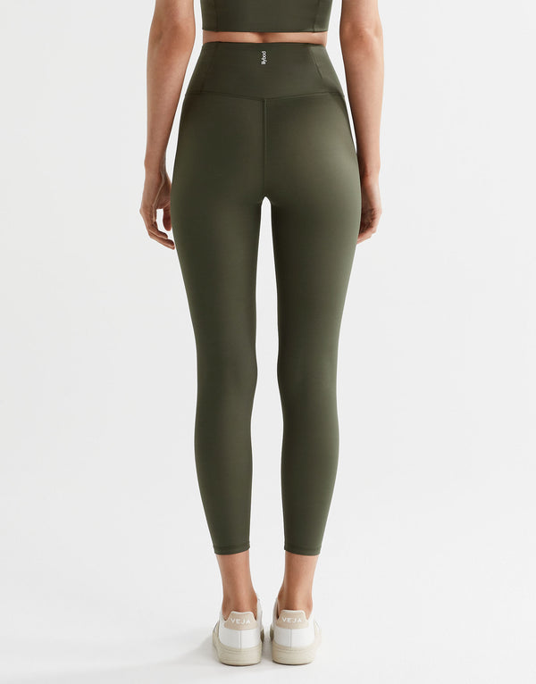 Person wearing olive green leggings on a white background