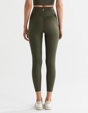 Person wearing olive green leggings on a white background