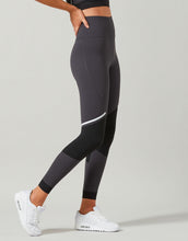 Person wearing black leggings with a white stripe on a light gray background