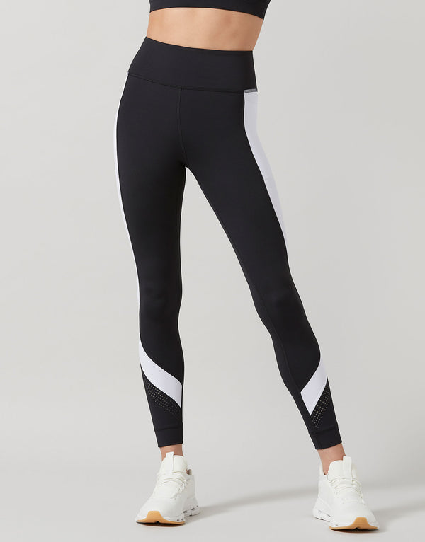 Black leggings with white stripes worn by a person on a gray background