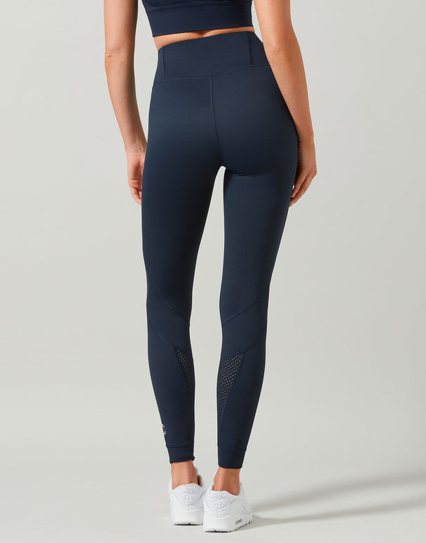 Person wearing navy leggings on a light gray background