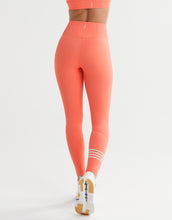 Coral leggings worn by a person on a white background
