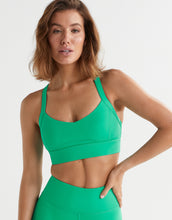 A model wearing a bright green athletic sports bra