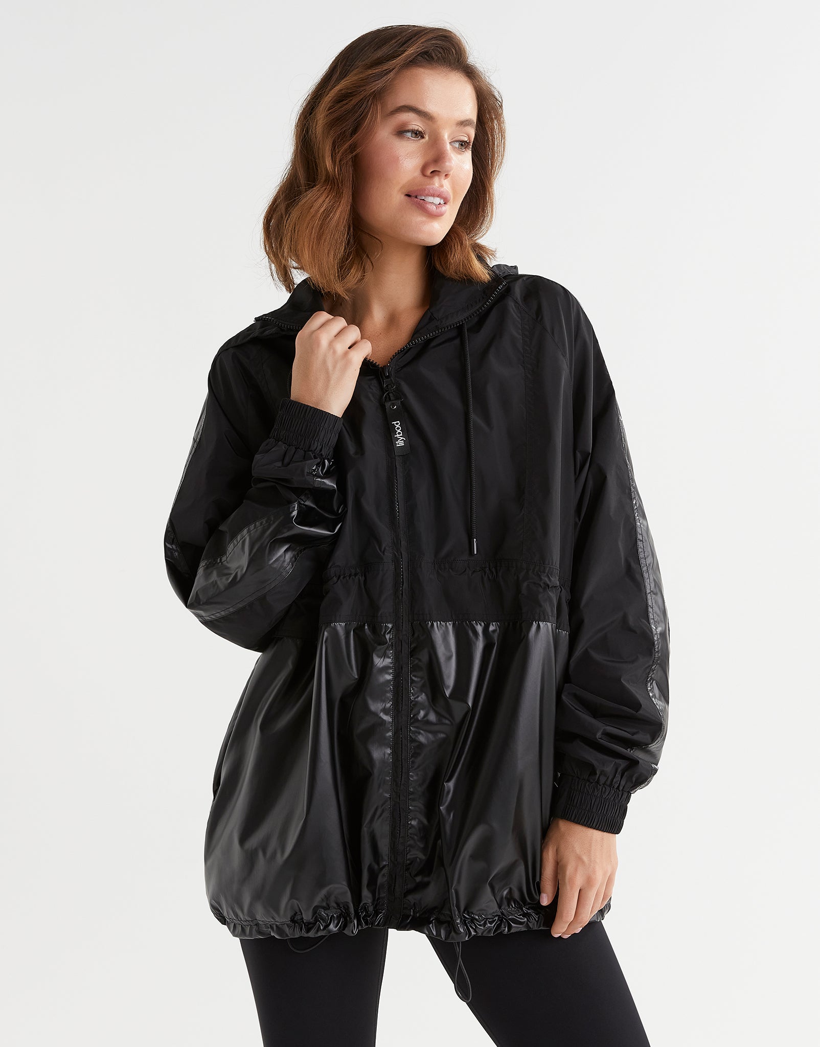 Woman wearing a black raincoat on a white background
