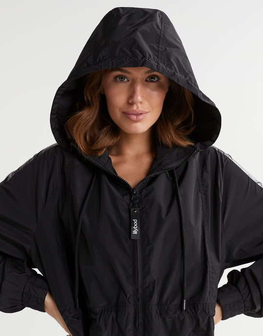 Person wearing a black hooded jacket on a white background