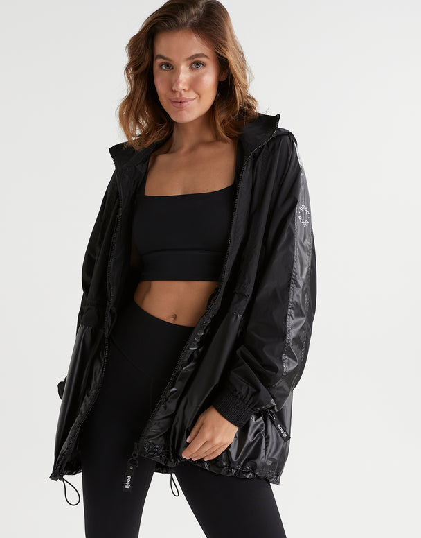 A woman wearing a black jacket and top and leggings.
