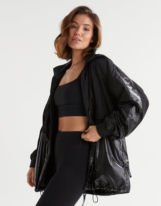 Woman wearing a black athletic outfit with a jacket on a white background