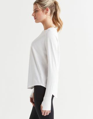 A female wearing a long-sleeved white t-shirt with a round neckline, paired with black leggings