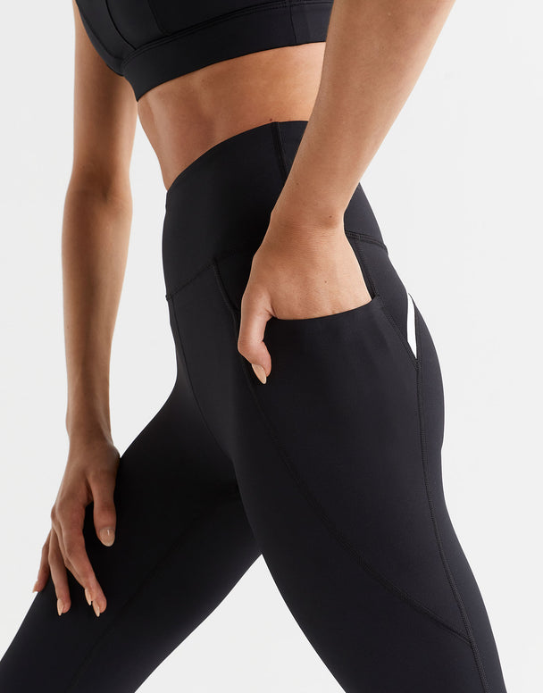 Person wearing black athletic leggings on a white background