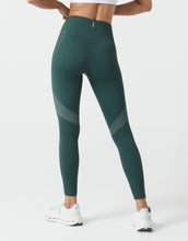 Green leggings with white accents worn by a person on a white background