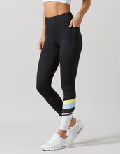 Black leggings with colorful stripe worn by a person on a light gray background