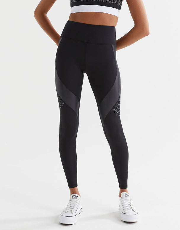 Person wearing black athletic leggings with a white background