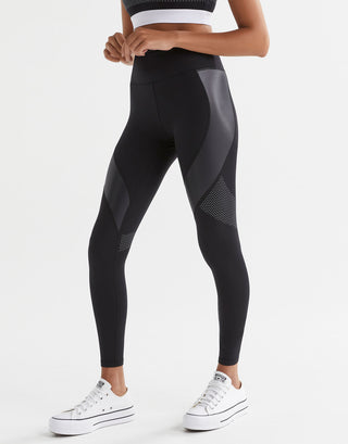 Person wearing black leggings with gray accents on a white background