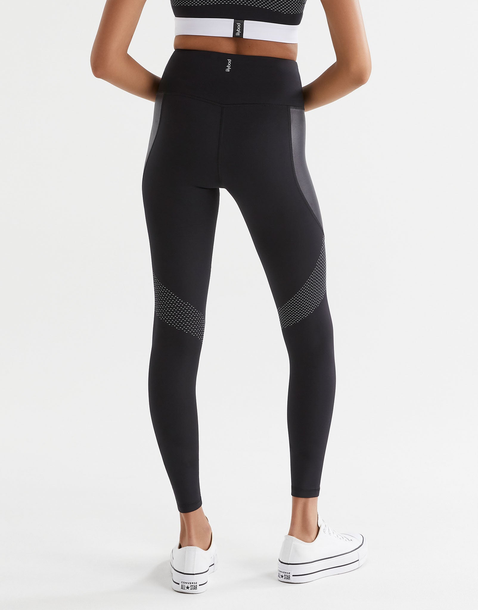 Black leggings with white accents worn by a person on a white background