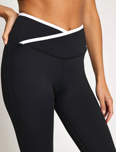 Black leggings with white accents worn by a person on a light gray background