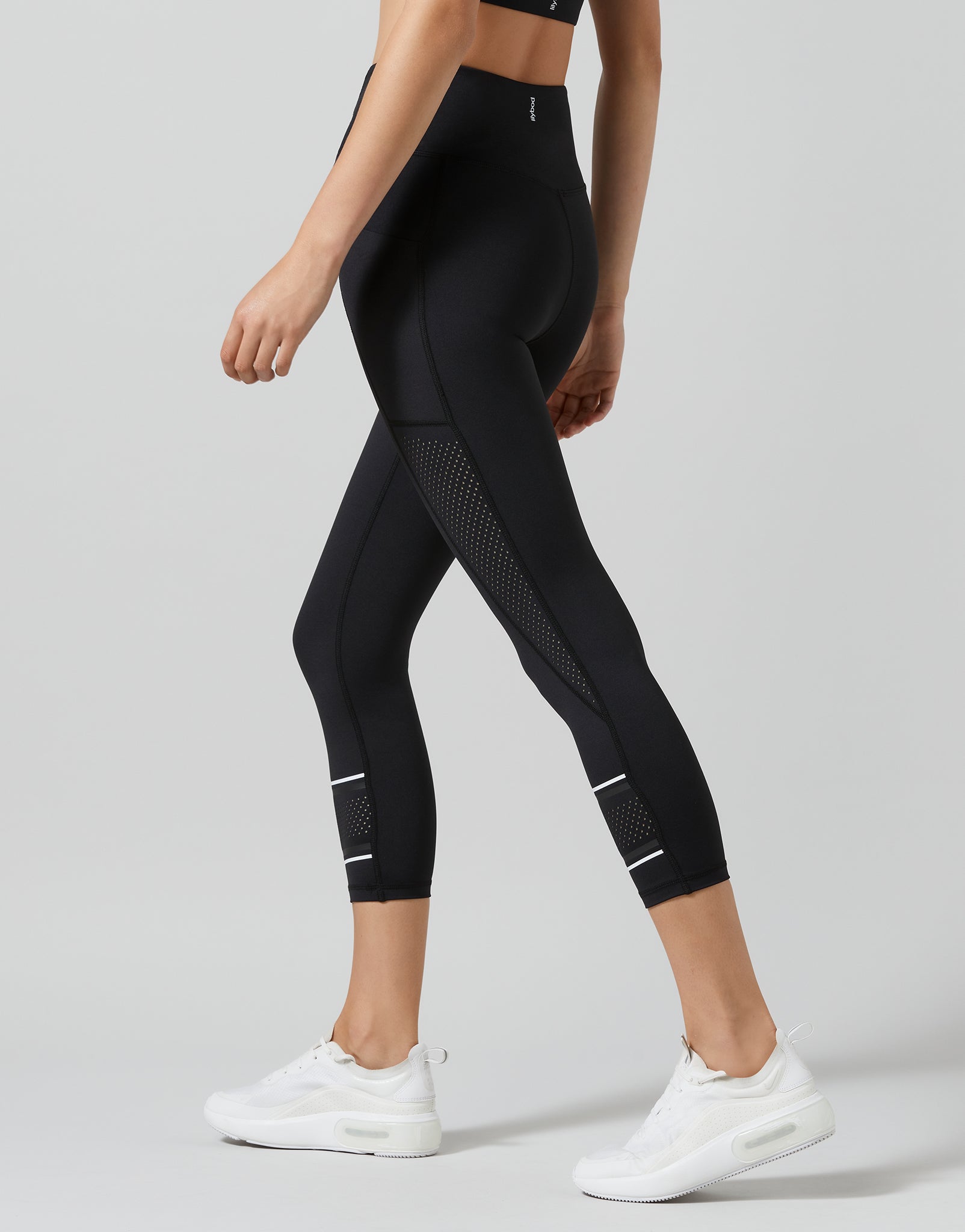 Black leggings with white accents worn by a person on a light gray background