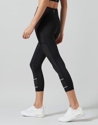 Black leggings with white accents worn by a person on a light gray background