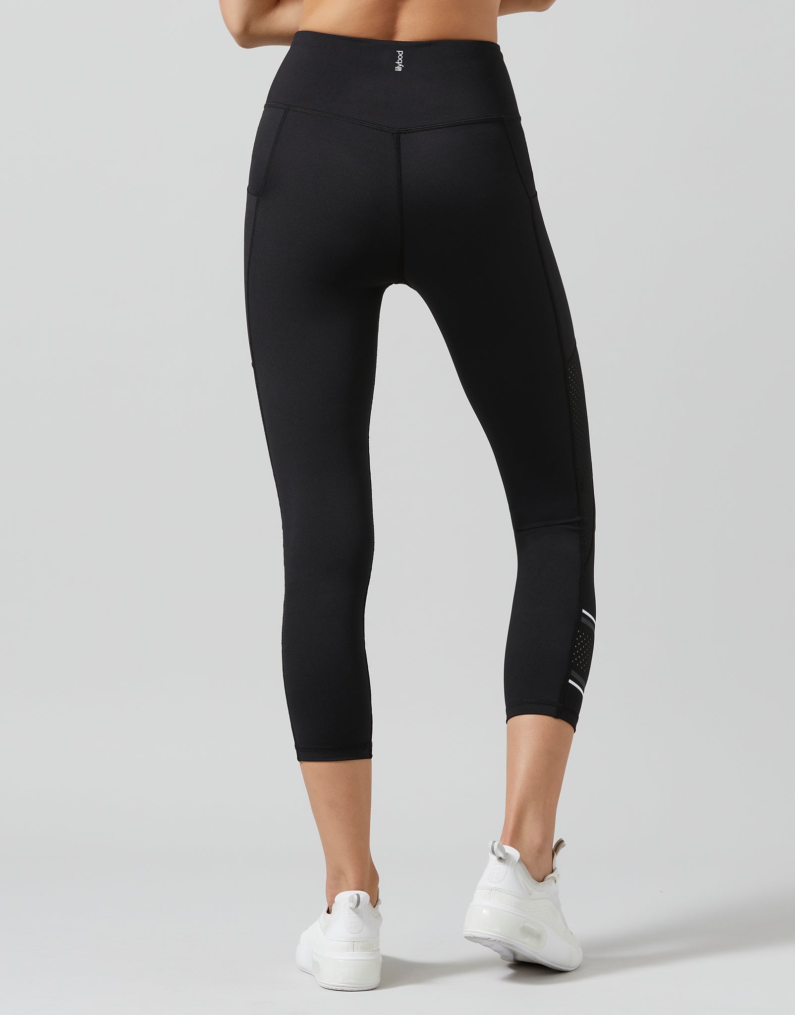 Black leggings worn by a person on a gray background