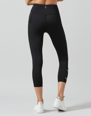 Black leggings worn by a person on a gray background