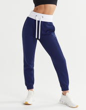 Navy blue jogger pants with white drawstring on a light gray background