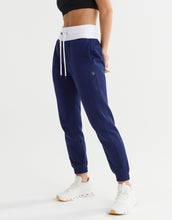 Person wearing navy blue jogger pants with a white drawstring on a white background