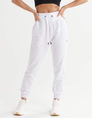 White jogger pants worn by a person on a white background
