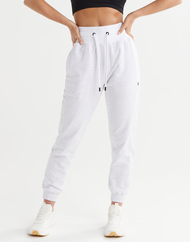 White jogger pants worn by a person on a white background