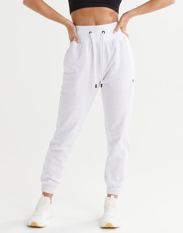 White jogger pants worn by a person on a white background