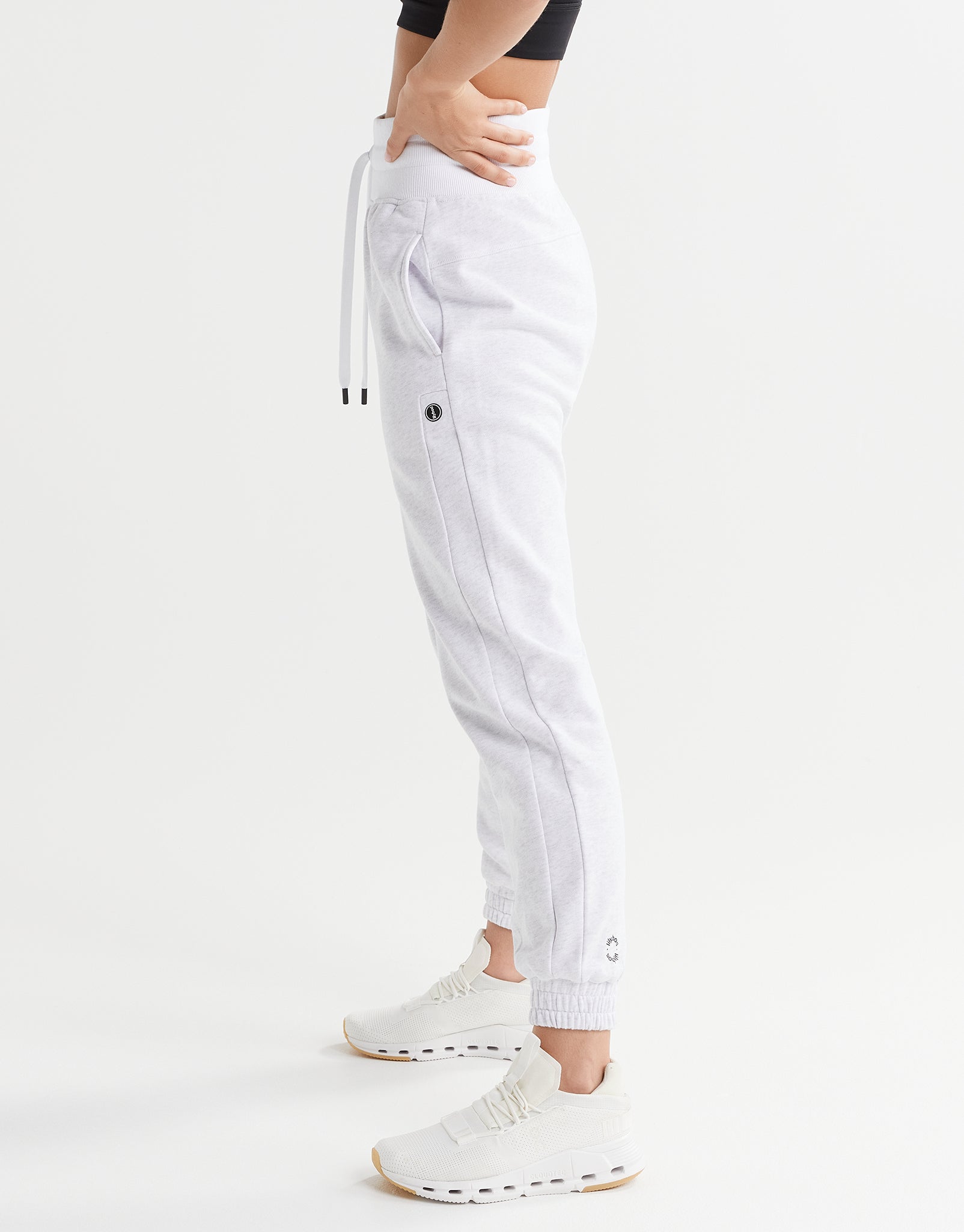 White jogger pants worn by a person on a white background