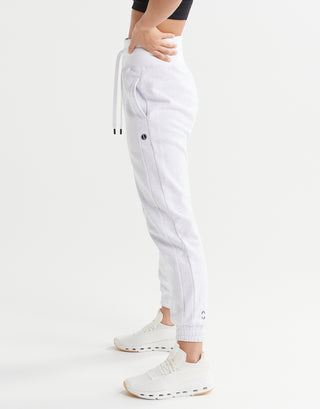 White jogger pants worn by a person on a white background