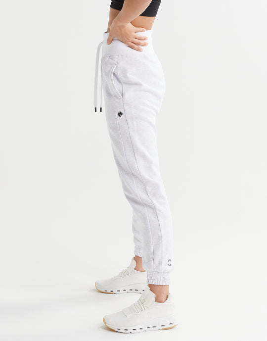 White jogger pants worn by a person on a white background