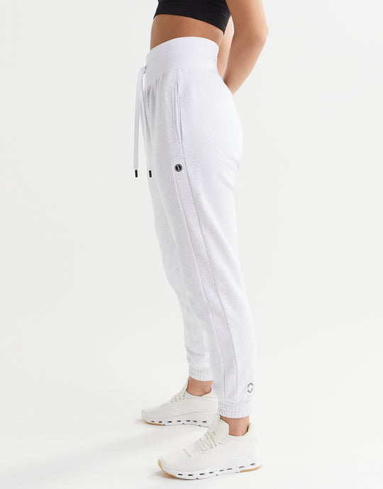 White jogger pants worn by a person on a white background