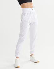 White jogger pants worn by a person on a white background