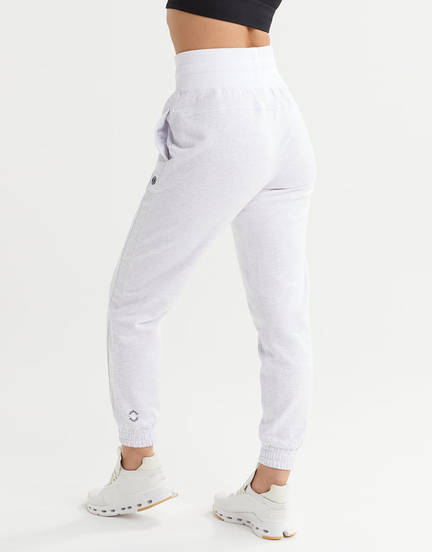 White jogger pants worn by a person on a white background