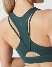 Green sports bra with cut-out design on a white background