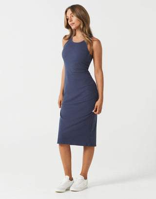 Woman wearing a navy blue sleeveless dress on a white background